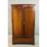 A circa 1900 mahogany wardrobe, with a dentil cornice over two doors, above a single drawer, on ogee