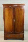 A circa 1900 mahogany wardrobe, with a dentil cornice over two doors, above a single drawer, on ogee