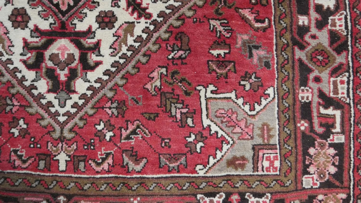 A hand made Persian Heriz carpet with central medallion on a madder field. L.201 W.158cm - Image 7 of 8