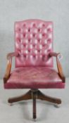 A Gainsborough style mahogany desk chair, upholstered in buttoned burgundy leather, with open