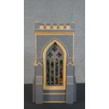 A scratch built matchstick model of a church tower, grey painted, with gothic arched stained glass