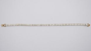 A 9ct yellow gold and cubic zirconia line bracelet. Set with 54 round cubic zirconias in open back