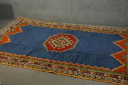 A Moroccan carpet with central medallion on sapphire ground within stylised multiple borders. L.