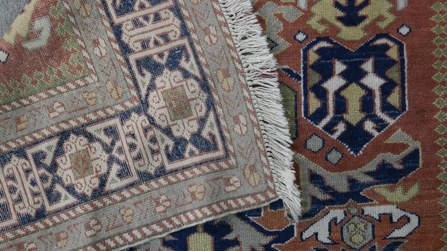 A handmade Russian Shirvan carpet with repeating stylised motifs on a pale terracotta ground - Image 7 of 7