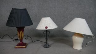Three table lamps, including a painted and gilded table lamp, a wrought iron scrolling design lamp
