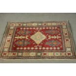 A hand made red ground Chechen Kazak rug. L.150 W.115cm.