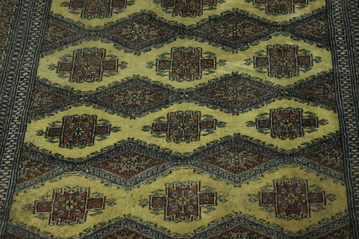A Pakistan Bokhara rug with repeating stylised foliate motifs on a biscuit ground within multiple - Image 2 of 5