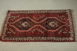 A hand made red ground Shiraz rug. L.130 W.82cm.