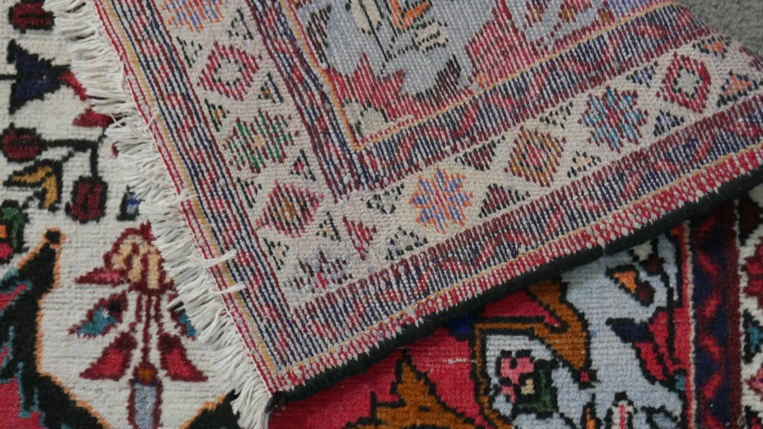 A handmade Persian Hamadan rug with repeating floral motifs across the madder ground within - Image 7 of 7