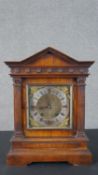 A Victorian architectural mantel clock, with an arched cornice over a frieze of roundels, above a