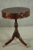 A Regency style drum form mahogany circular occasional table, with two drawers and four faux
