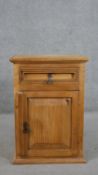 A Continental pine bedside cabinet, with a single drawer over a cupboard door, on a plinth base. H.