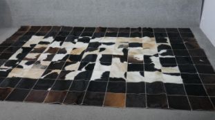 A contemporary cow hide carpet, formed of stitched squares of cow hide. L.303 W.203cm