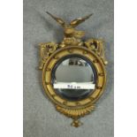 A C.1900 carved giltwood Regency design convex mirror, surmounted by an eagle, the frame with ball
