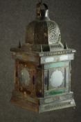 An early 20th century Moroccan brass lantern, the domed top pierced with decoration, the glazed