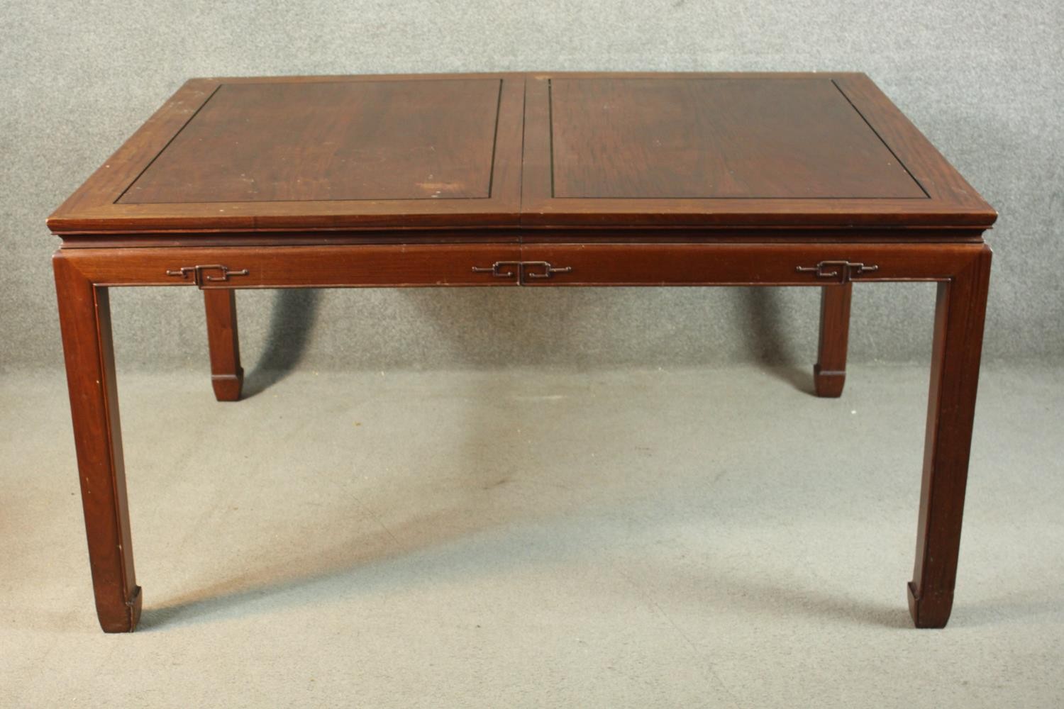 A late 20th century Chinese rosewood dining table, with a rectangular top and two additional leaves,
