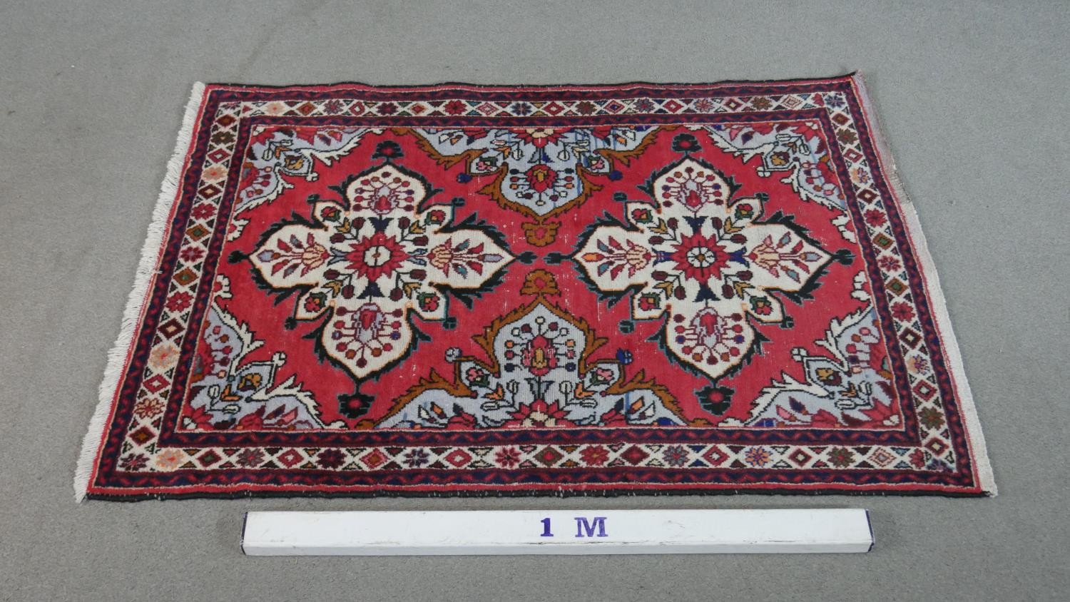 A handmade Persian Hamadan rug with repeating floral motifs across the madder ground within - Image 2 of 7