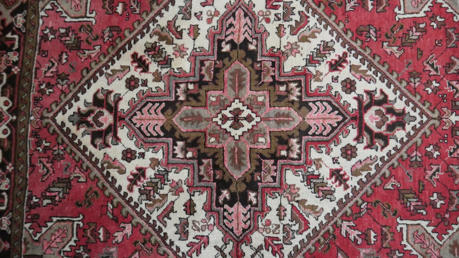 A hand made Persian Heriz carpet with central medallion on a madder field. L.201 W.158cm - Image 3 of 8