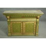 A green painted and parcel gilt cabinet, with a gadrooned cornice, above a frieze of scales, over