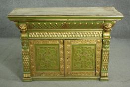 A green painted and parcel gilt cabinet, with a gadrooned cornice, above a frieze of scales, over