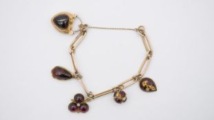 A Victorian 18 carat yellow gold link bracelet with four Victorian Garnet cabochon set charms.