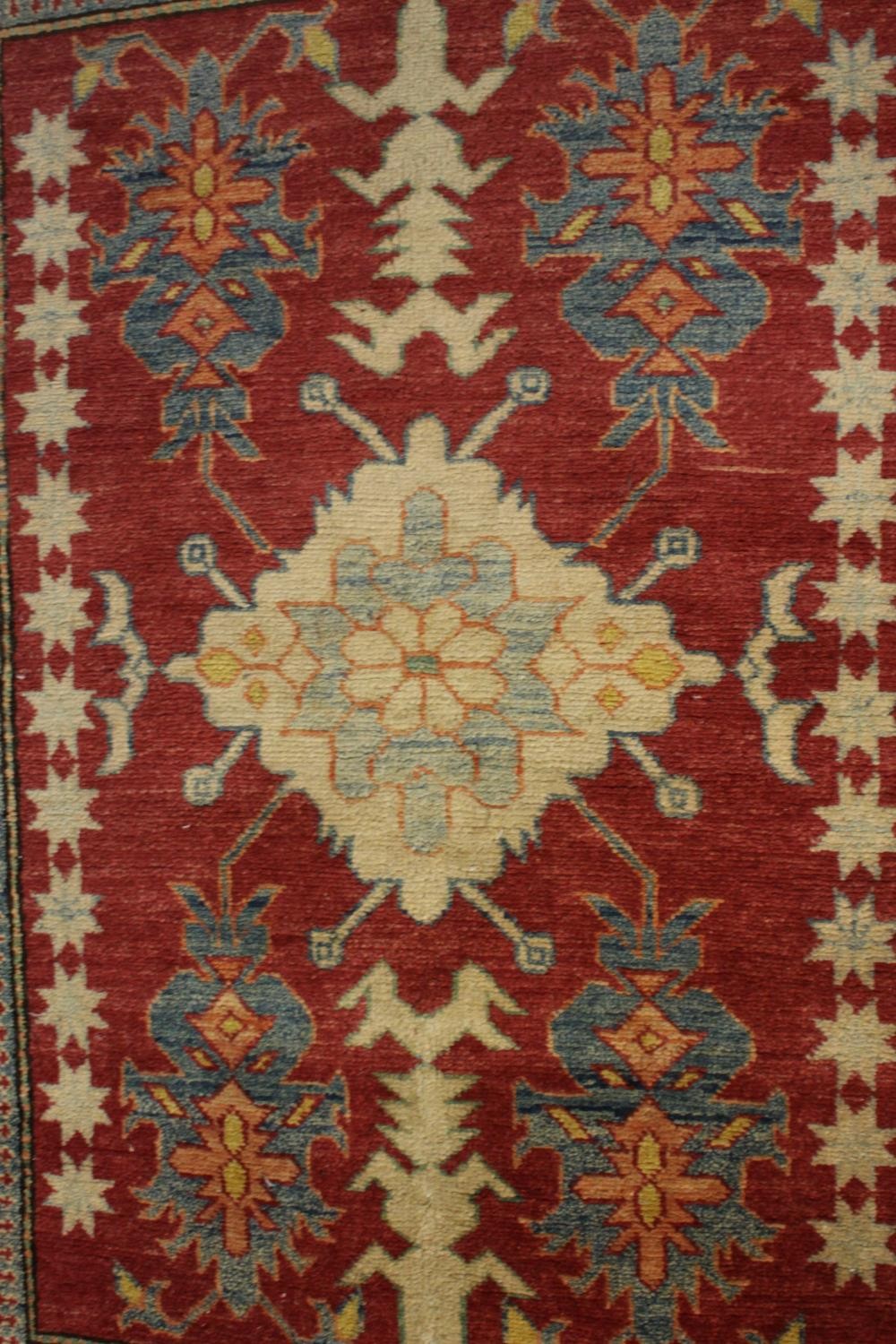 A hand made red ground Chechen Kazak rug. L.150 W.115cm. - Image 4 of 6