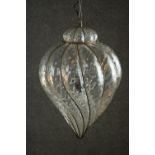 A clear wrythen glass ceiling light, in an iron wire frame, of bulbous form with a pointed tip. H.70
