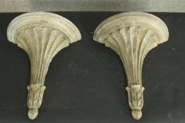 A pair of demi lune corbels, grey painted and distressed wood with gilt highlights. H.30 W.26cm.