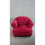 A contemporary Harto armchair, upholstered in crimson suede style fabric, with a buttoned back,