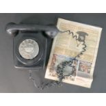 A black diakon Modern T 700 Series telephone, with a copy of the Daily Mail Weekend Puzzle Magazine,
