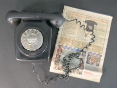 A black diakon Modern T 700 Series telephone, with a copy of the Daily Mail Weekend Puzzle Magazine,