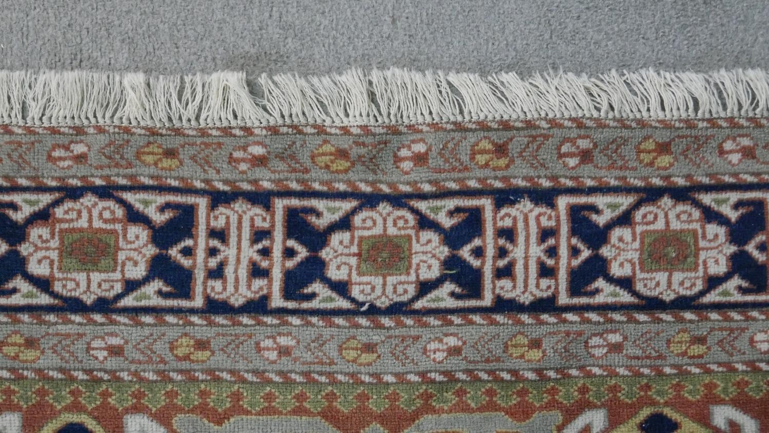 A handmade Russian Shirvan carpet with repeating stylised motifs on a pale terracotta ground - Image 6 of 7
