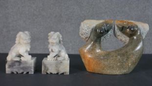 A pair of Chinese carved soapstone Foo dogs on rectangular stands along with an African stone
