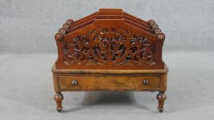 An early Victorian walnut Canterbury, with pierced dividers, over a single drawer, on turned legs.