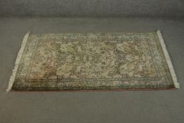 A hand made beige ground silk Kashmir Persian carpet. L.210 W.120cm.
