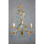 A contemorary three branch gilt metal chandelier, decorated with oak leaves, hung with blue glass