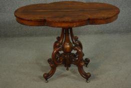 A Victorian rosewood centre table, with a cartouche top, on a carved and turned quatraform base,