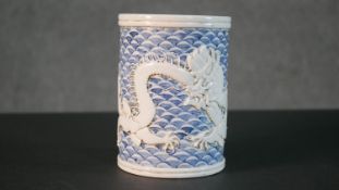 A 19th century relief dragon design porcelain brush pot with hand painted blue and white scale