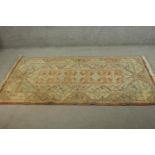 A hand made apricot ground Turkish Milas carpet. L.196 W.120cm.