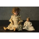 Two 19th century dolls. One smaller in size with a painted mache head and plaster hands and feet,
