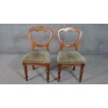 A pair of Victorian walnut balloon back dining chairs, upholstered in green velour, on turned legs.