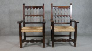 A pair of rustic spindle back open armchairs, with open arms and rush seats, on square section