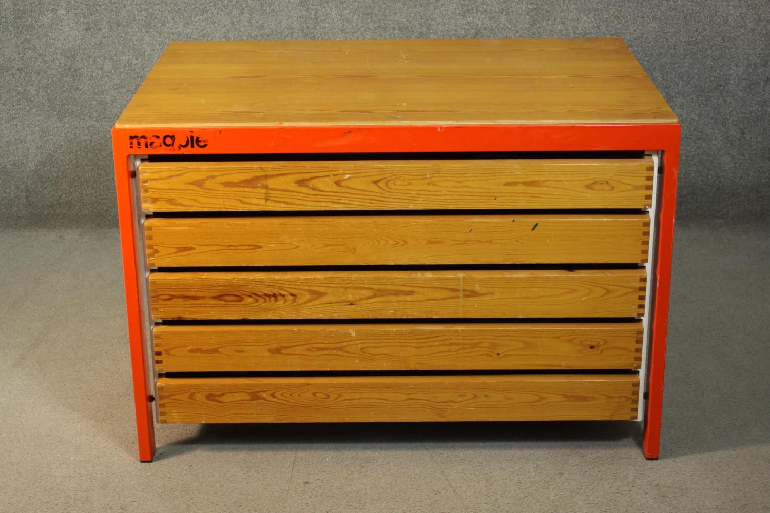 A Magpie pitch pine plan chest of five long drawers, in a red and white metal frame. H.71 W.105 D.