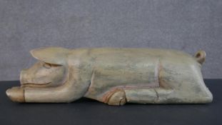 A carved and painted Oriental pig figure. H.14 W.54 D.15cm