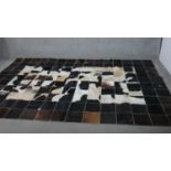 A contemporary cow hide carpet, formed of stitched squares of cow hide. L.303 W.203cm