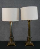 A pair of Victorian brass column design table lamps each on a square base with lion paw feet. H.80