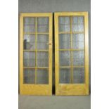 A pair of vintage simulated oak doors, lead set with textured glass panels, the reverse of one