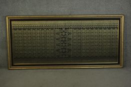 A framed and glazed Indian black ground and gold thread woven silk work. H.90 W.189cm.