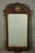 A George III parcel gilt mahogany fretwork mirror, with a carved and pierced stylised leaf over a