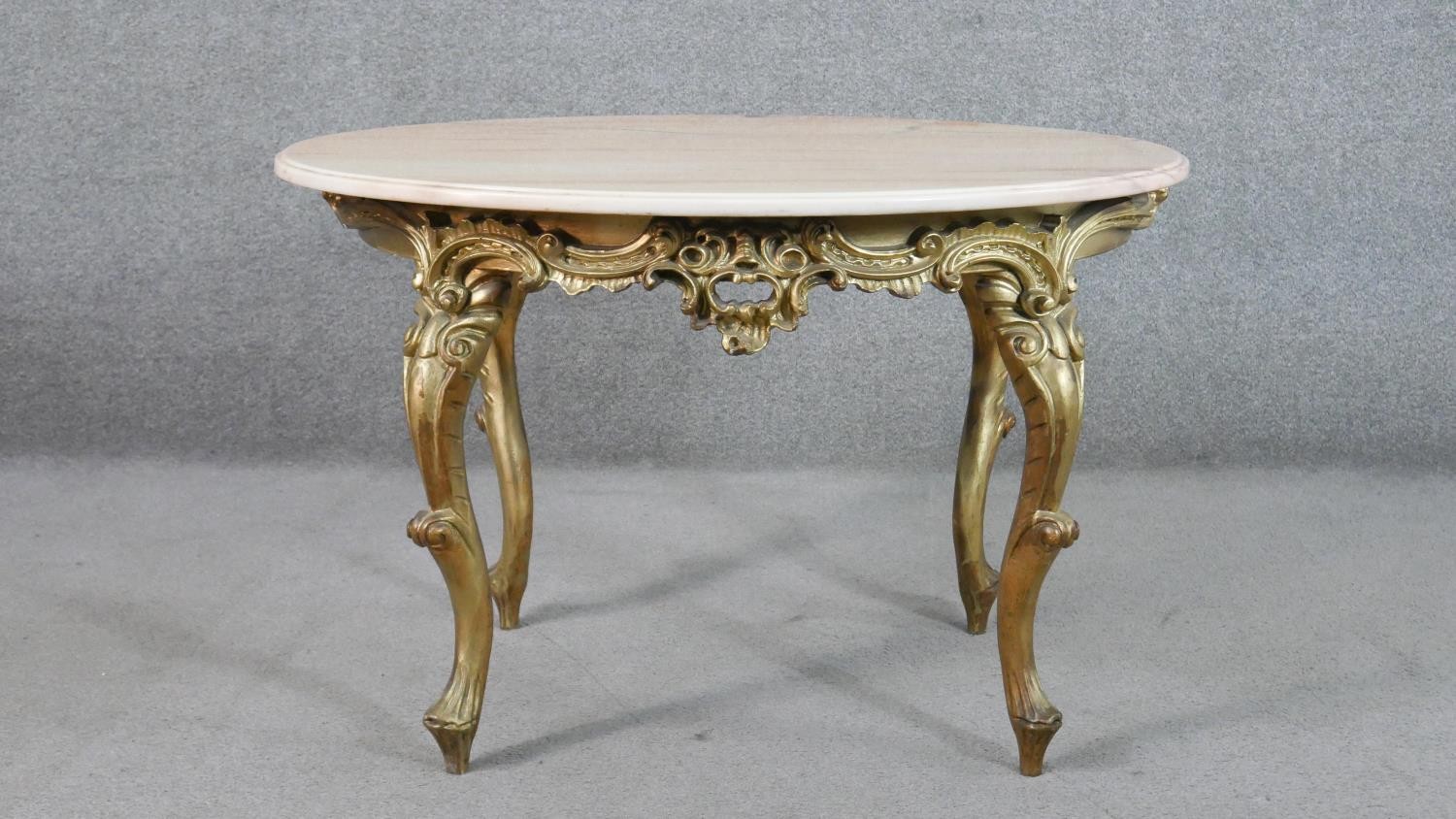 A Continental, probably Italian, carved giltwood table, the circular white marble top with a moulded